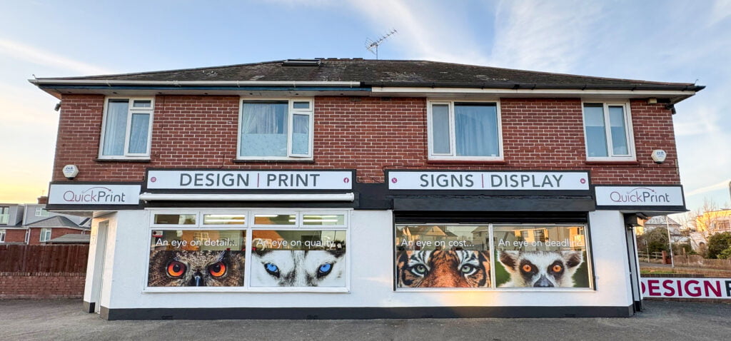QuickPrint store front, displaying professional signage with eyes of various animals.