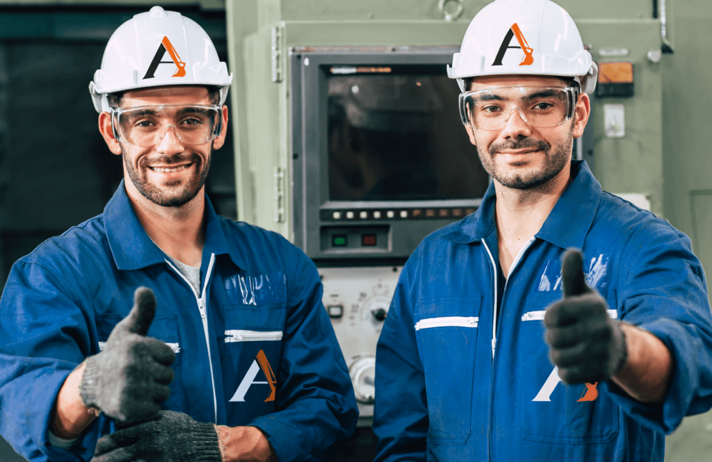 A pair of construction workers with branded uniforms; coveralls and hard hats, giving thumbs up